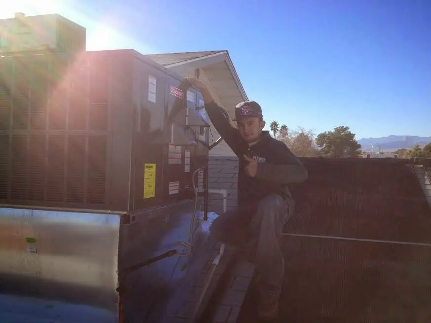HVAC technician performing Air Duct Cleaning on a rooftop unit in Hawthorne
